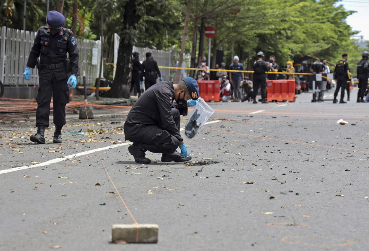 Poliisit tutkivat onnettomuuspaikkaa katolisen kirkon vieressä Makassarissa Indonesiassa maanantaina 29. maaliskuuta.