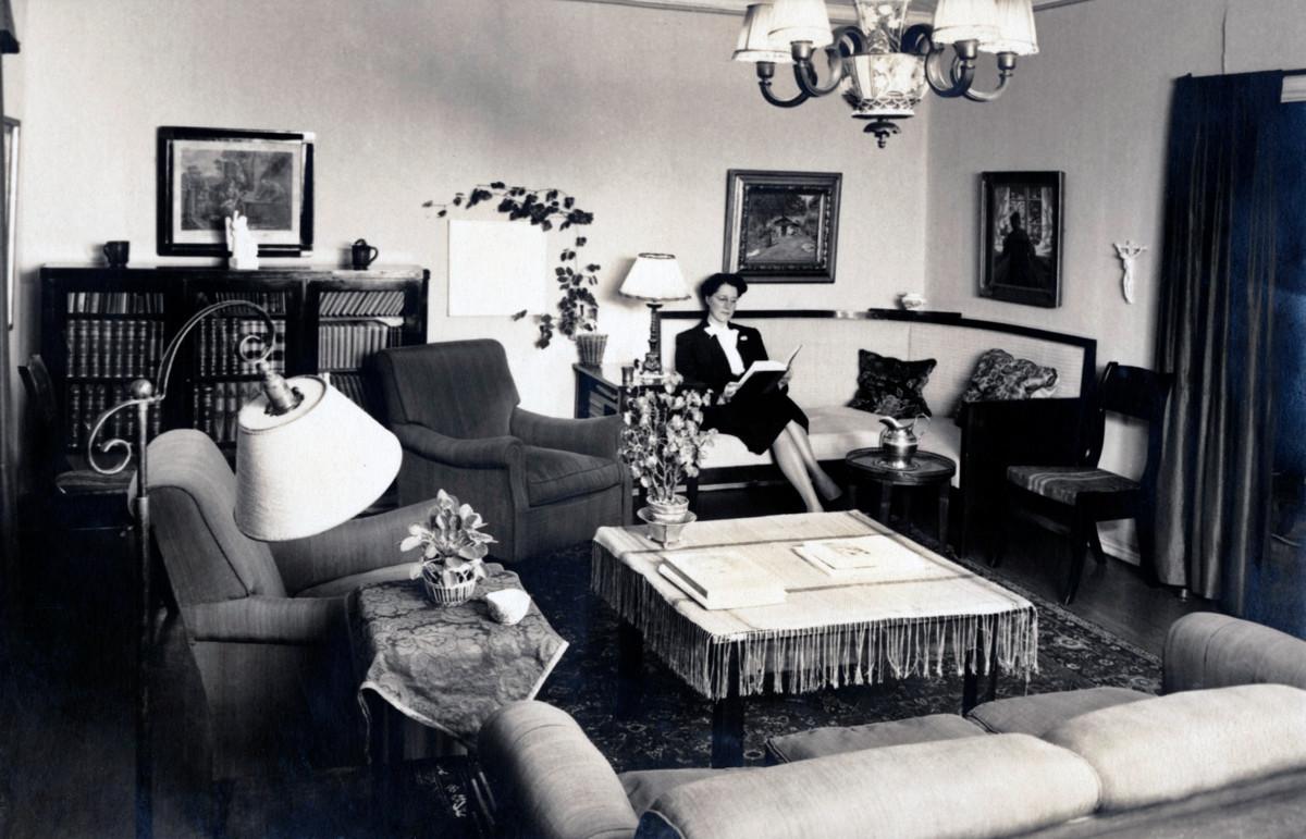 Kirkkoherran rouva Sylvia Wirén lukee Kulosaaren pappilan olohuoneessa. Kuva vuodelta 1950.