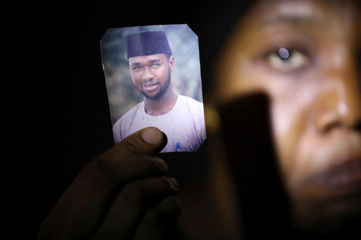 Nigerialainen Amina Ahmed näyttää jumalanpilkan vuoksi vangittuna pidetyn miehensä Mubarak Balanin kuvaa maaliskuussa 2021. Pohjois-Nigeriassa syyte jumalanpilkasta voi johtaa kuolemanrangaistukseen. Kuva: AFP / Lehtikuva