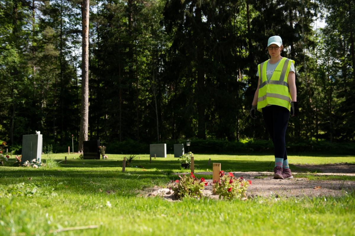 Maija Roiha tarkastelee työjohtajan kanssa mittaamiaan muslimien hautapaikkoja, joiden merkkinä puiset tikut ovat. Islamilaisella hautausmaalla paikat mitataan eri tavalla kuin kristillisellä hautausmaalla, kertoo Roiha.