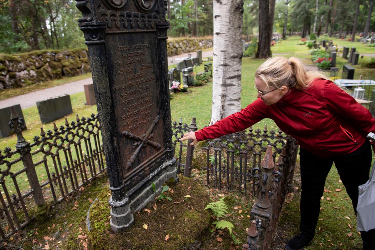 Heli Haavisto tutkii Viilatehtaan omistajien vaimon ja lasten haudalle pystytetyn muistomerkin symbolia.