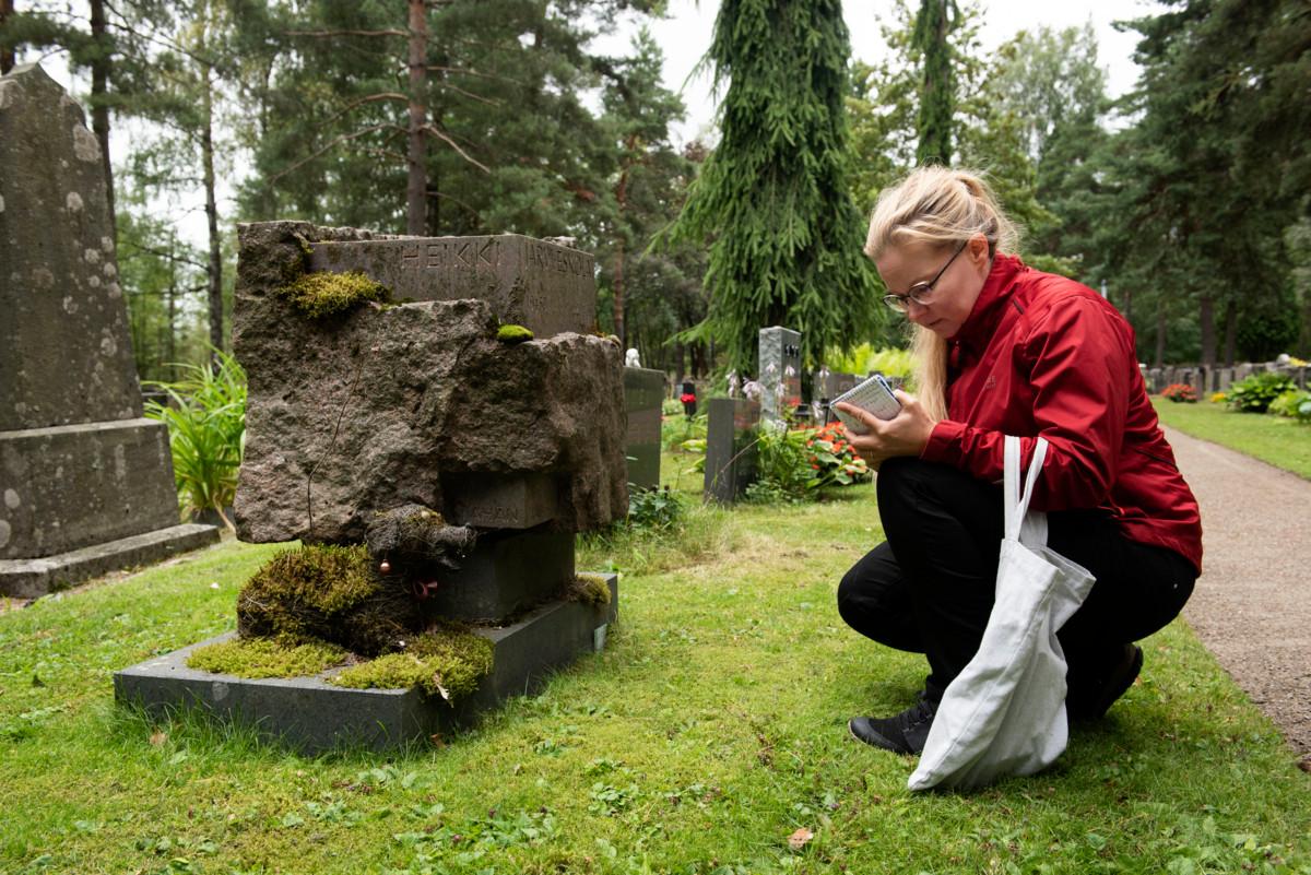 Heli Haavisto tekee muistiinpanoja kuvanveistäjä Heikki Häiväojan suunnittelemasta hautakivestä. Kiven juurella oleva mäyräkoira on lisätty patsaan muistomerkin jalustalle myöhemmin.
