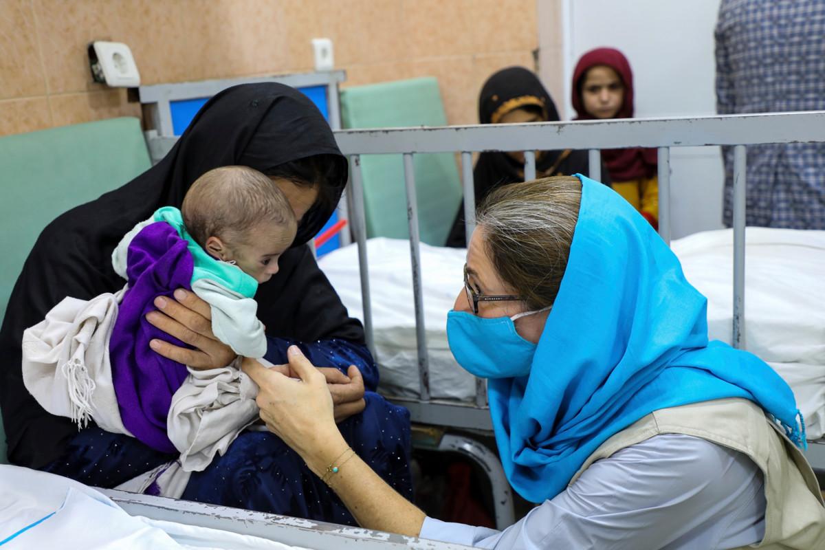 Unicefin Afganistanin tiimin viestintäpäällikkö Sam Mort juttelee aliravitsemuksesta kärsivälle lapselle Indira Gandhin lastensairaalassa Kabulissa. Kuva on otettu 24.8. Sairaalan henkilökunnasta 170 on naisia.