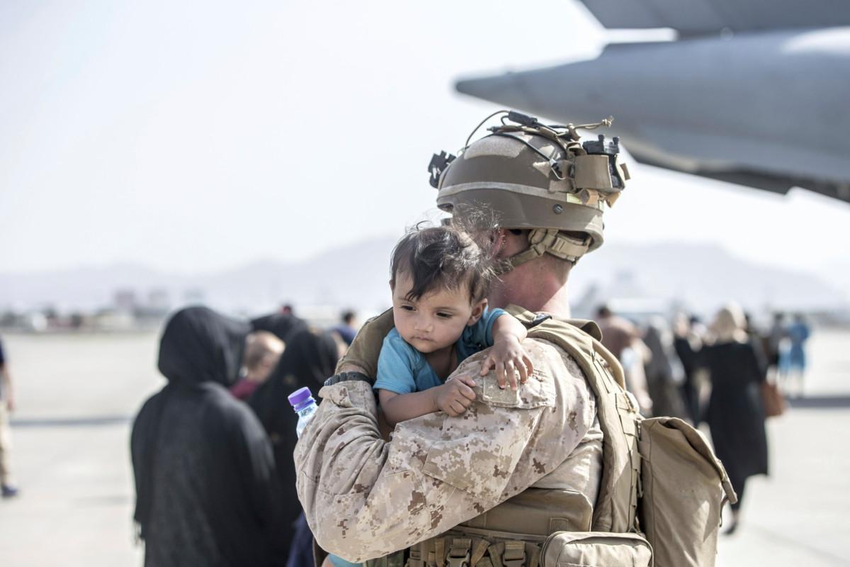 Amerikkalainen merijalkaväen sotilas rauhoittelee afganistanilaislasta 21. elokuuta Afganistanin pääkaupungin Kabulin lentokentällä. Kuva: DPA / Lehtikuva / Samuel Ruiz – US Marine Corps IV.