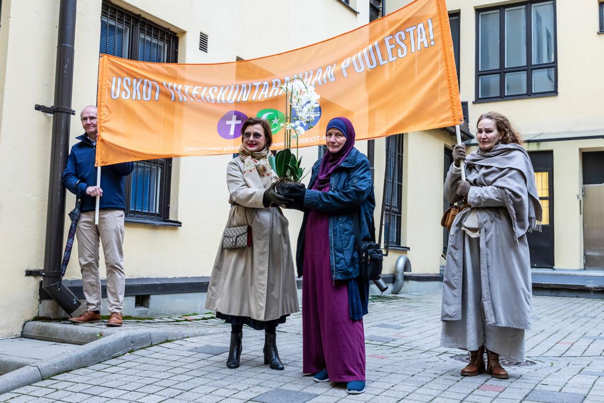 Islamilaisen Yhdyskunnan moskeijalla USKOT-foorumin puheenjohtaja Pia Jardi vastaanotti kukkatervehdyksen USKOT-foorumin varapuheenjohtajalta, juutalaisia kävelyllä edustaneelta Yvonne Westerlundilta (vasemmalla).