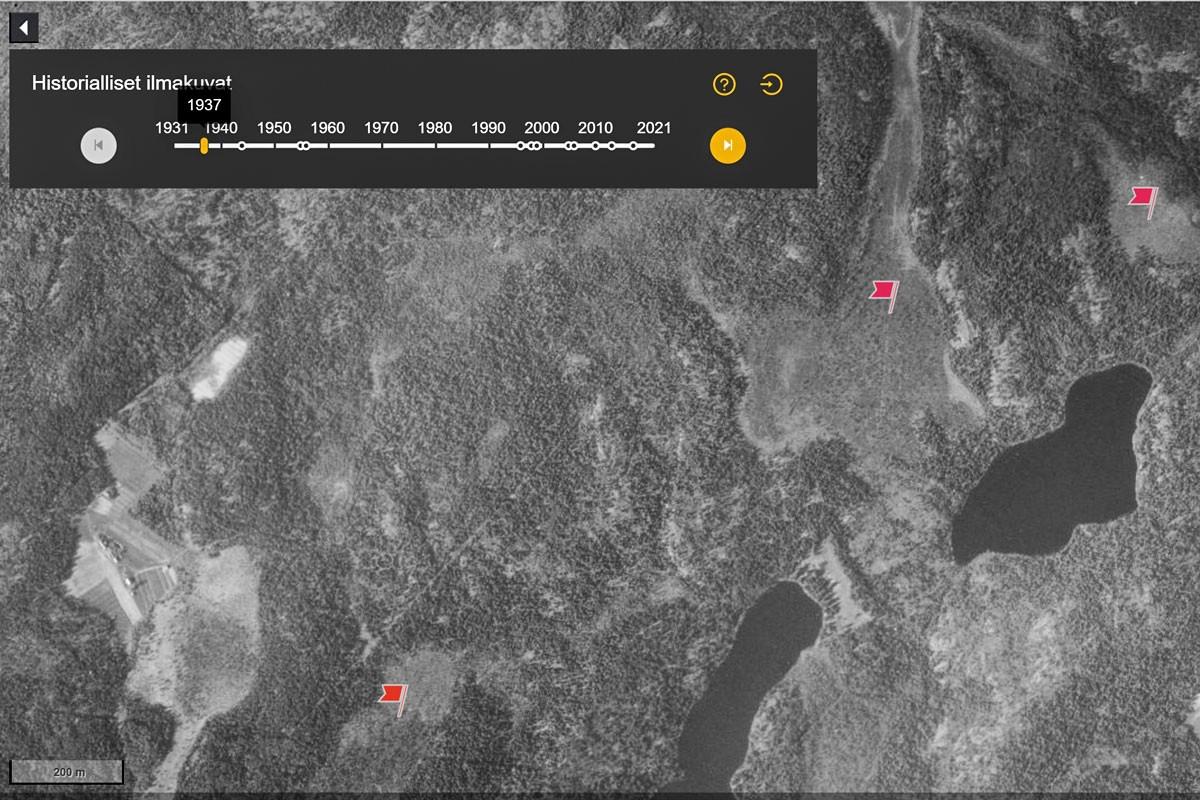 Maanmittauslaitoksen karttapalvelun kuvakaappauksessa näkyy vanha ilmakuva Stormossenista. Olli Turunen on merkinnyt ennallistettavat suoalueet lippumerkeillä.