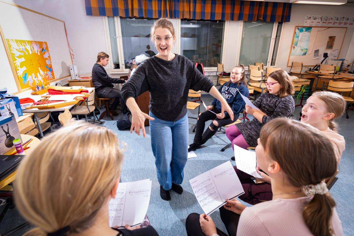 Aurinkotanssi-kuoron Jenna Kainulainen (vas.), Lotta Vilenius, Josefina Nelin, Hilda Ahola ja Helmi Ahola harjoittelevat Hoosiannaa Vilho Aholan säestyksellä. Keskellä kuoronjohtaja Sini Nikku. 