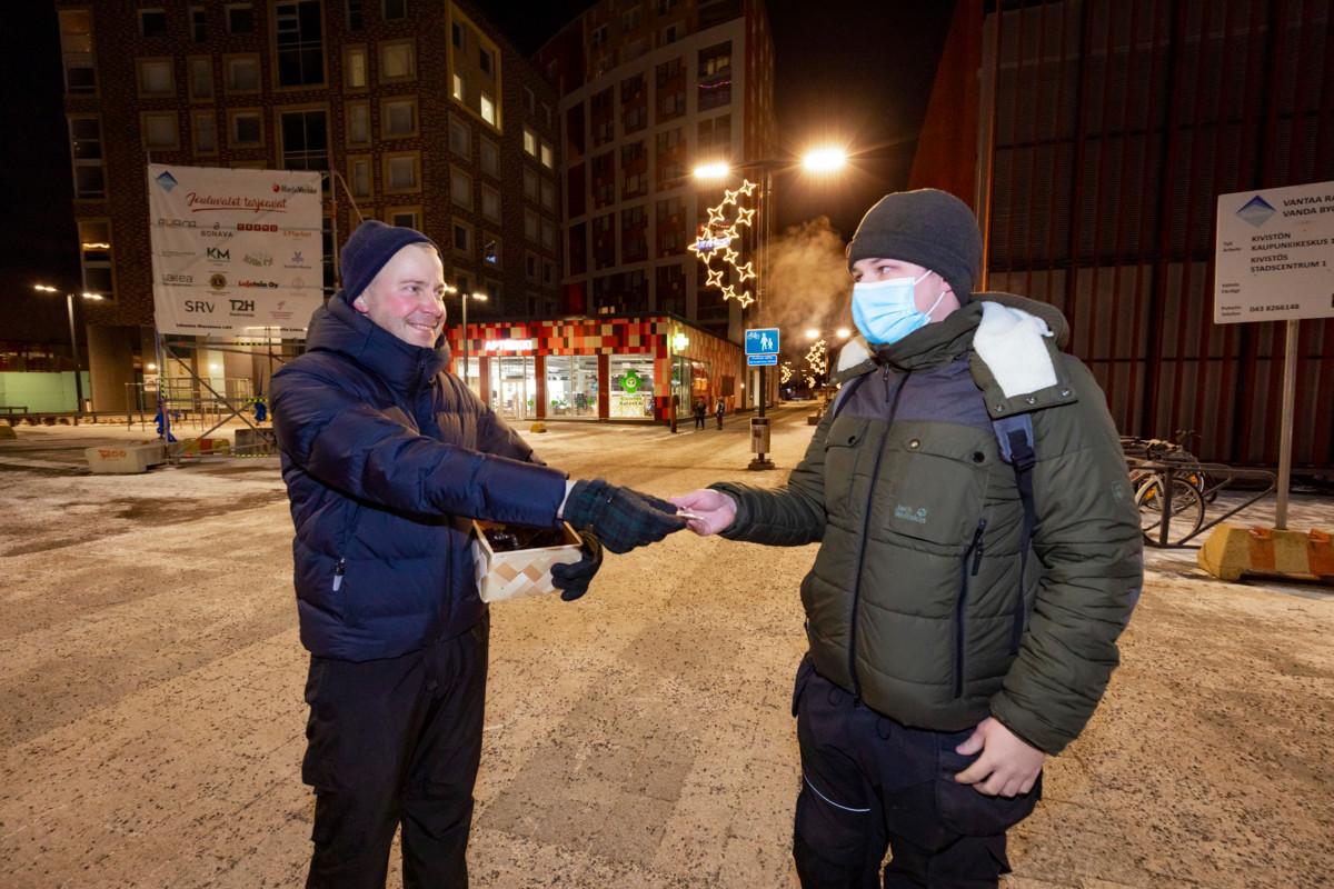 Vantaan seurakuntayhtymä jakoi heijastimia Kivistön asemalla 2.12.2021. Pappi Aki Kekkonen antaa heijastimen Jesse Kososelle.