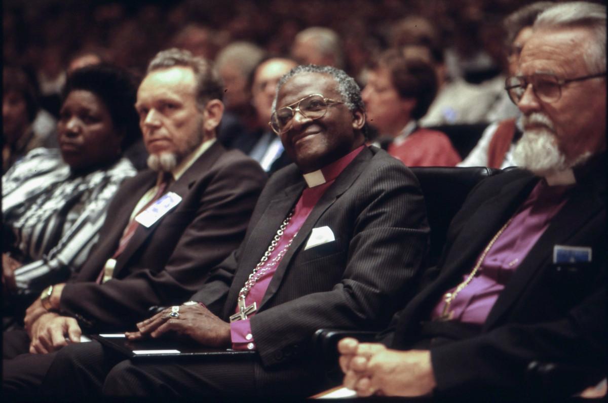 Eteläafrikkalainen arkkipiispa Desmond Tutu vierailulla Kirkkopäivillä Suomessa elokuussa 1987. Kuvassa vasemmalta Hufvudstadsbladetin päätoimittaja Håkan Hellberg, arkkipiispa Desmond Tutu ja Helsingin piispa Samuel Lehtonen. Kuva: Timo Korhonen / Kirkon kuvapankki
