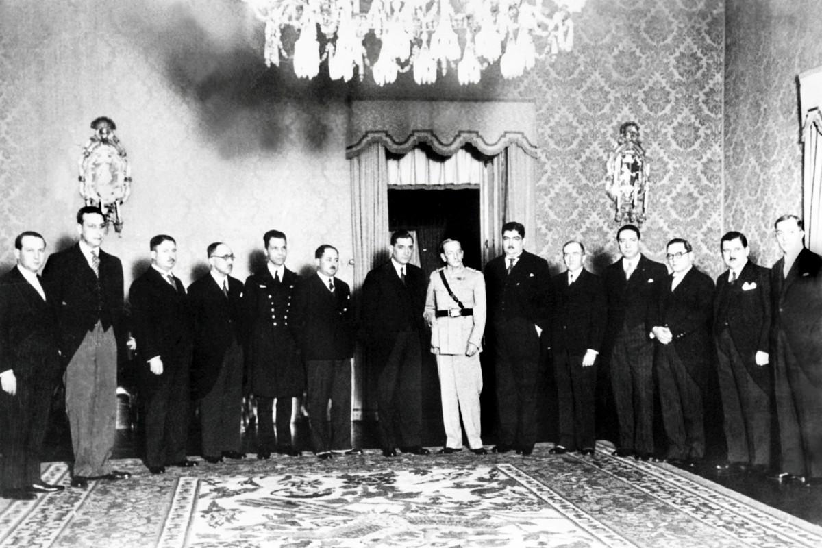 Portugalin diktaattiória Antonio de Oliveira Salazar (kuvassa seitsemäs vasemmalta) hallitsi maataan pääministerinä vuosikymmeniä. Hän oli taloustieteen professori. Diktaattorit ympäröivät itsensä myötäilijöillä. Salazar joutui luopumaan vallasta aivoinfarktin jälkeen, mutta hänelle ei uskallettu kertoa, ettei hän ole enää pääministeri.