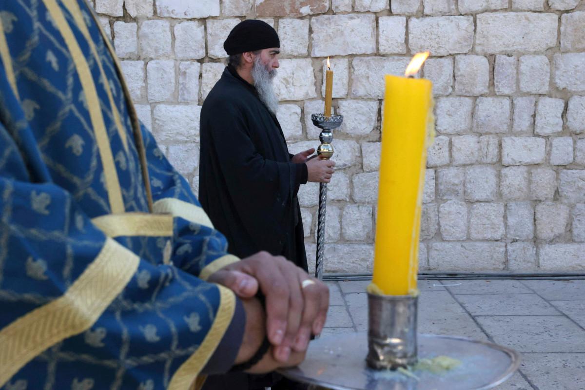 Ortodoksipappi sytytti kynttilän Jeesuksen syntymäkirkon luona Betlehemissä 6. tammikuuta. Palestiinan ja Israelin alueella asuvan kristityn vähemmistön elämä konfliktialueella ei ole helppoa.
