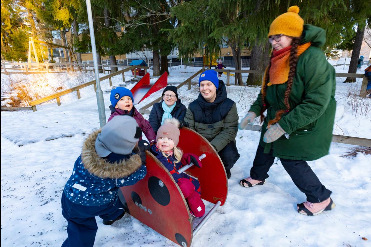 Flora (selin), Hiski ja Vivian leikkivät päiväkoti Lokin pihalla. Kanttori Aino Valojärvi (keskellä) sekä lastenohjaajat Joel Niemi ja Anu Lönnqvist työskentelivät Lokissa kaksi viikkoa.