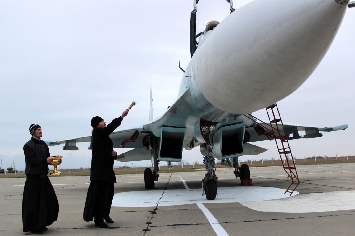 Venäjän ortodoksikirkon papit siunaavat venäläisen Sukhoi-hävittäjäkoneen Sevastopolin liepeillä miehitetyllä Krimin niemimaalla vuonna 2014. Kuvituskuva. Kuva: Yuri Lashov / AFP / Lehtikuva