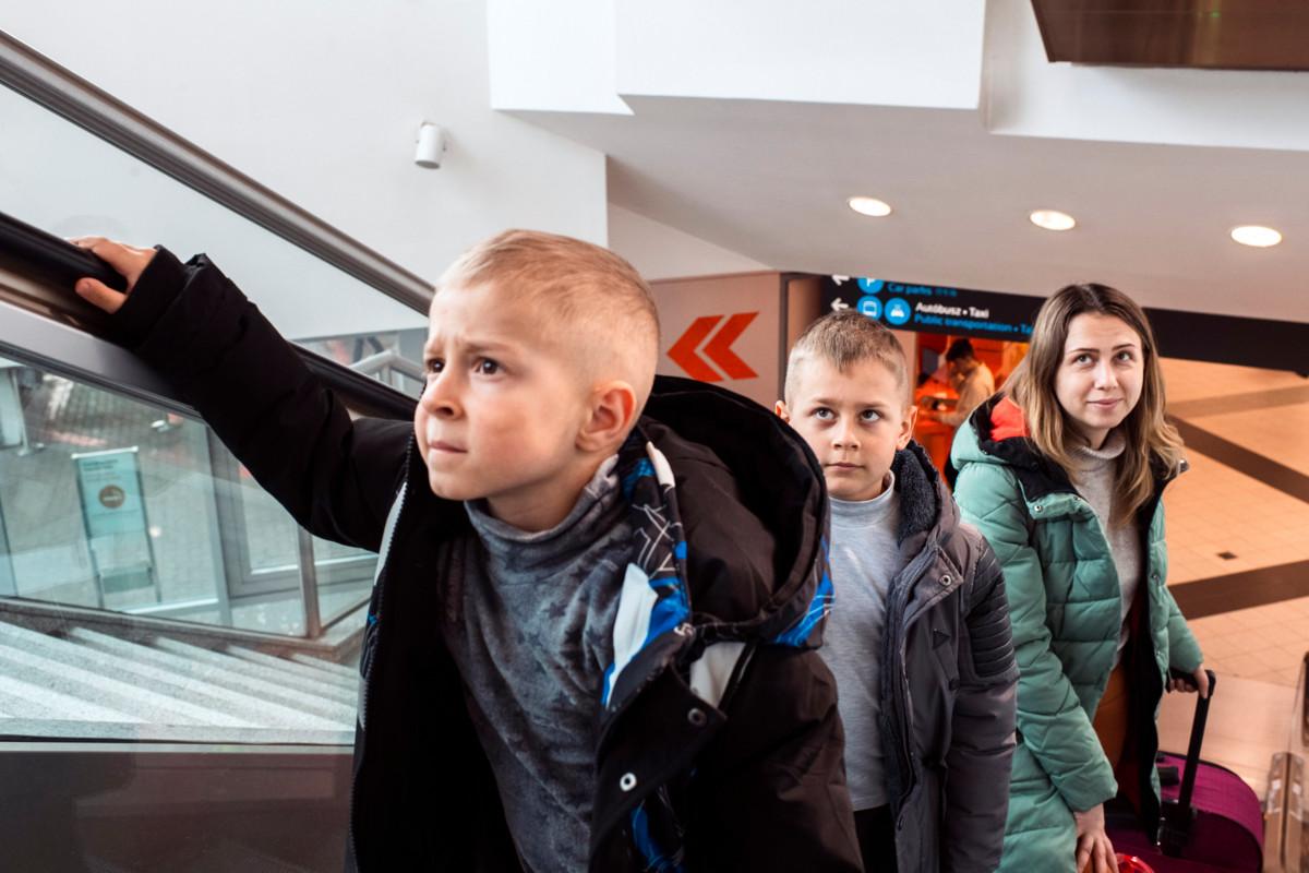 Vasemmalta: Dmitriy, 5, Daniil, 8, äiti Kate Pugachova Budepestin lentoasemalla. Perhe on lähtenyt pakoon Ukrainan Dniprosta ja on matkalla Istanbuliin, jossa ystäväperhe on luvannut majoittaa heidät.