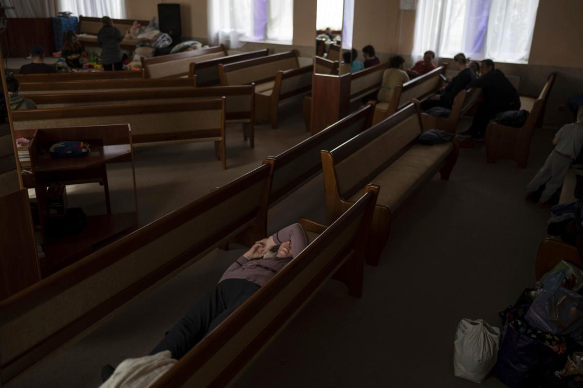 Ihmisiä lepäämässä kirkon penkeissä Bastankan kaupungissa, jonne he pakenivat Venäjän armeijan hyökkäystä kotikyliinsä. Kuva. Petros Giannakouris/AP/Lehtikuva