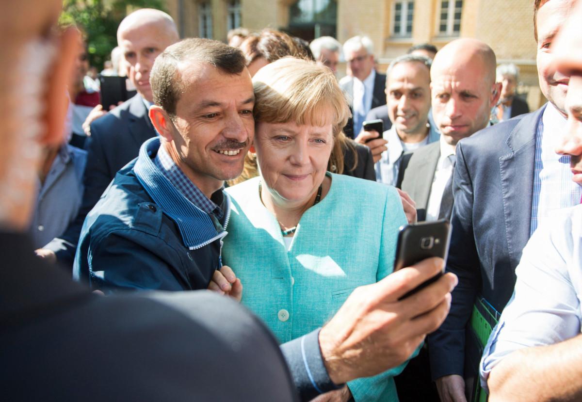 Turvapaikanhakija ottamassa selfietä liittokansleri Angela Merkelin kanssa syyskuussa 2015. Kuva: Bernd von Jutrczenka/AFP/Lehtikuva.