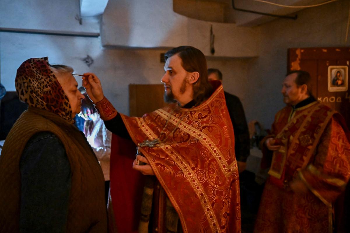 Samaan aikaan, kun Venäjän kirkon johtajat Moskovassa elävät vauraasti, Ukrainassa ortodoksit ovat sodan keskellä. Kuvassa pidetään jumalanpalvelusta kellarikirkossa. Kuva: Aris Messinis/AFP/ Lehtikuva. 