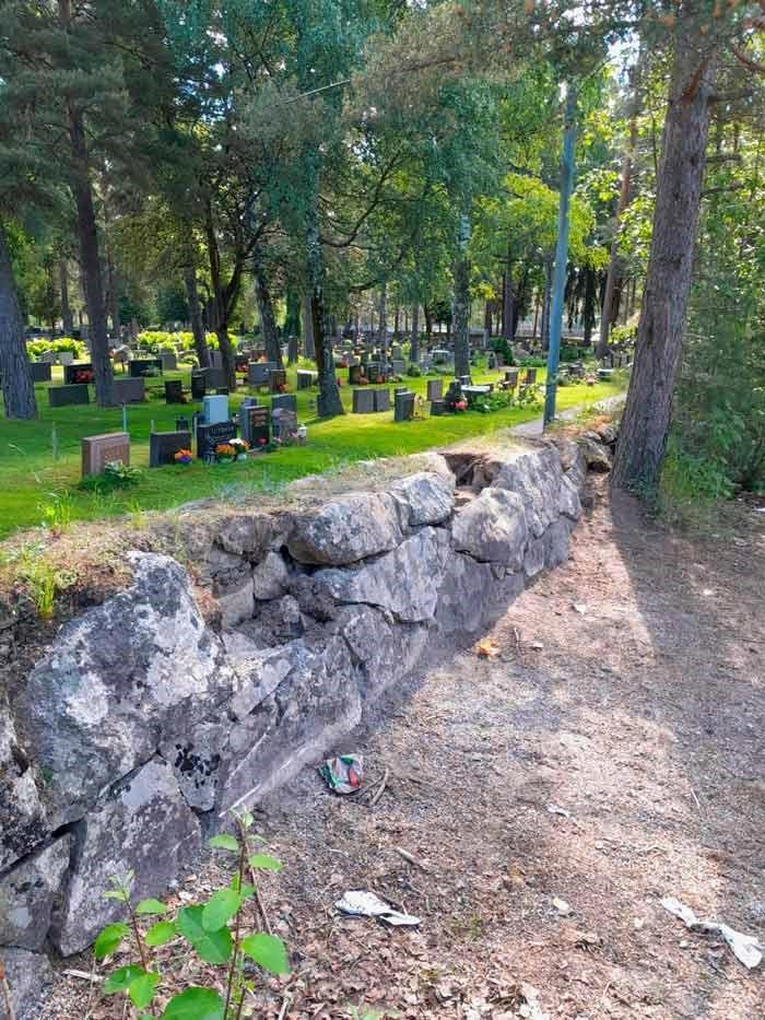 Kivimuurista irrotetut kivet on vieritetty läheiseen lampeen. Kuva: Minna Aho / Vantaan seurakunnat