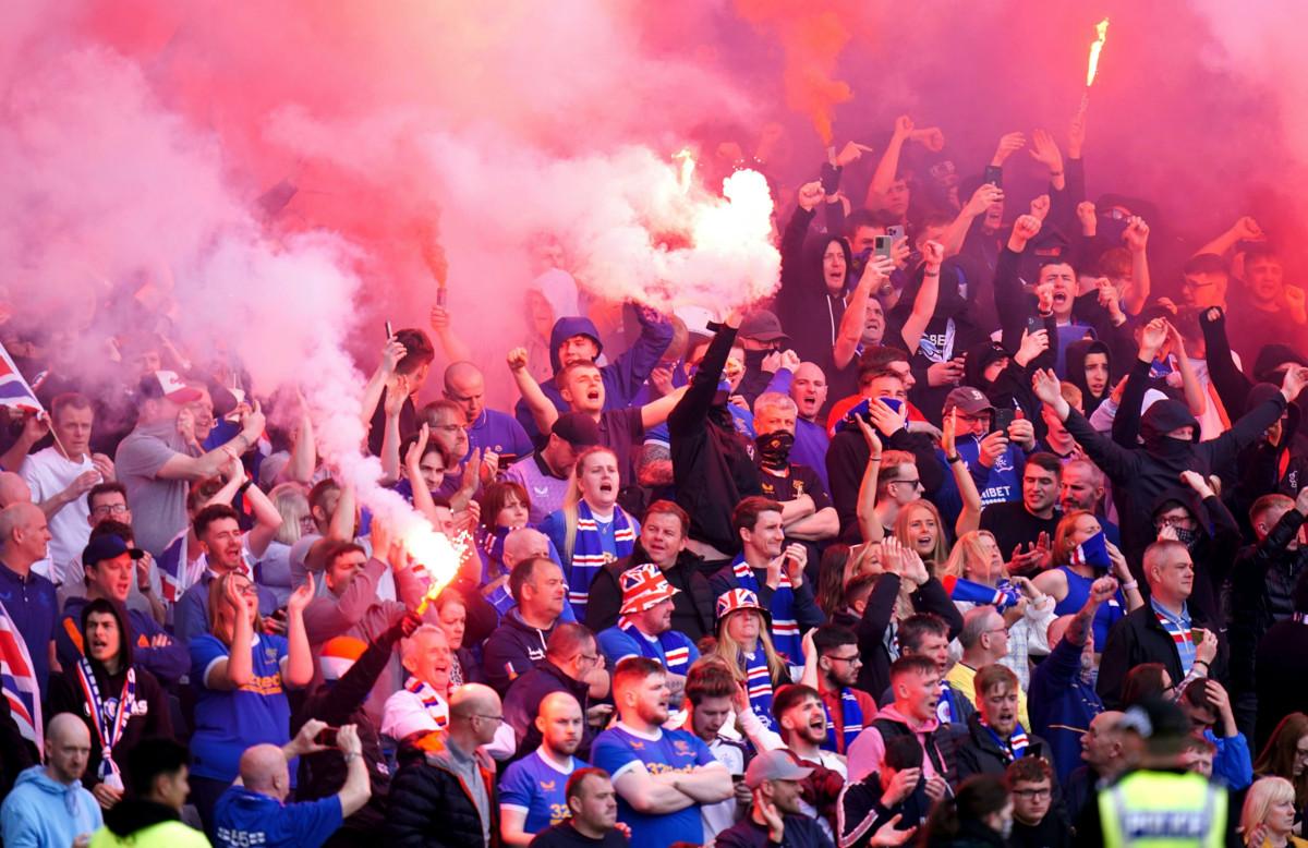 Rangersin fanit sytyttivät soihtuja paikallismatsissa. Fanien yllä näkyy Yhdistyneiden kuningaskuntien värejä. Kuva: Jane Barlow/Alamy/Lehtikuva.