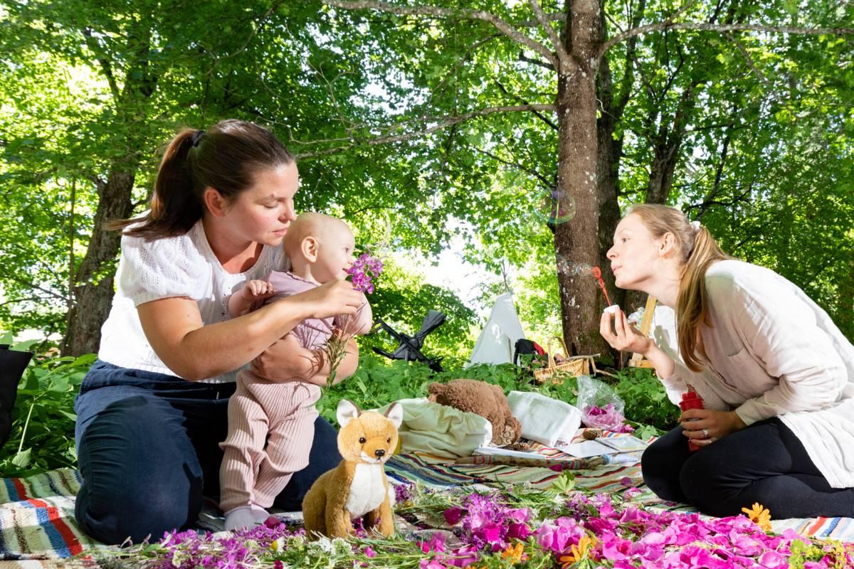 Vauvojen luontokylvyssä vauva tutkii luontoa kaikilla aisteillaan. Kuvassa Elle Saari äitinsä Nina Virkkalan ja ohjaaja Raakel Silvennoisen (oik.) kanssa.