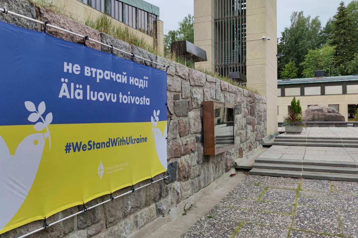 Lauttasaaren kirkon muurissa oleva banderolli osoittaa, että Helsingin seurakunnat haluavat tukea Ukrainaa.