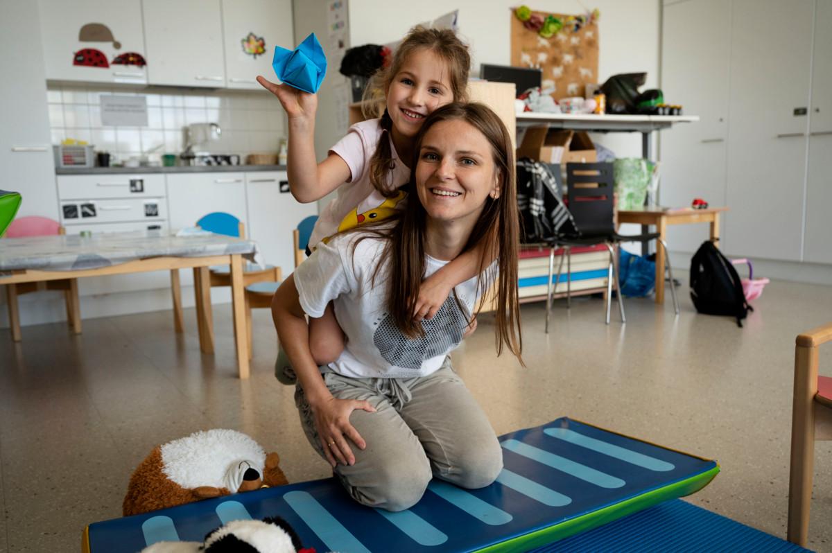 Kseniia Shepitko ohjaa ukrainalaisia lapsia Ison Omenan Chapplessa. Selässä Agnes, 5, näyttää askarreltua paperityötä.