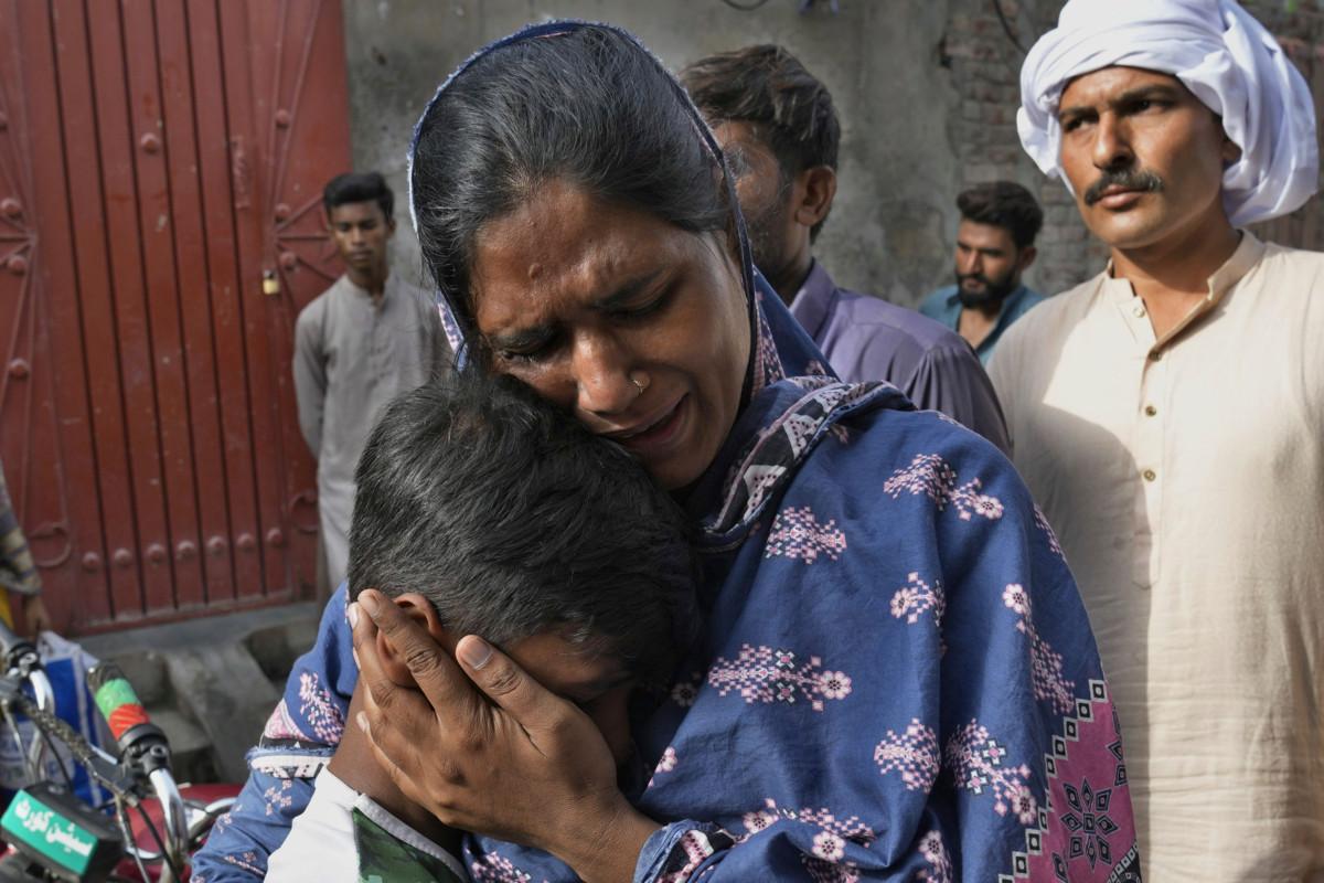 Kristitty nainen itkee poikansa kanssa tuhotun kotinsa luona. Epäily Koraanin halventamisesta johti siihen, että vihainen väkijoukko tuhosi kristittyjen asuntoja ja kirkkoa. Pakistanin poliisi pidätti yli sata tuhotyöhön osallistunutta. Kuva: K.M. Chaudary/AP/Lehtikuva. 