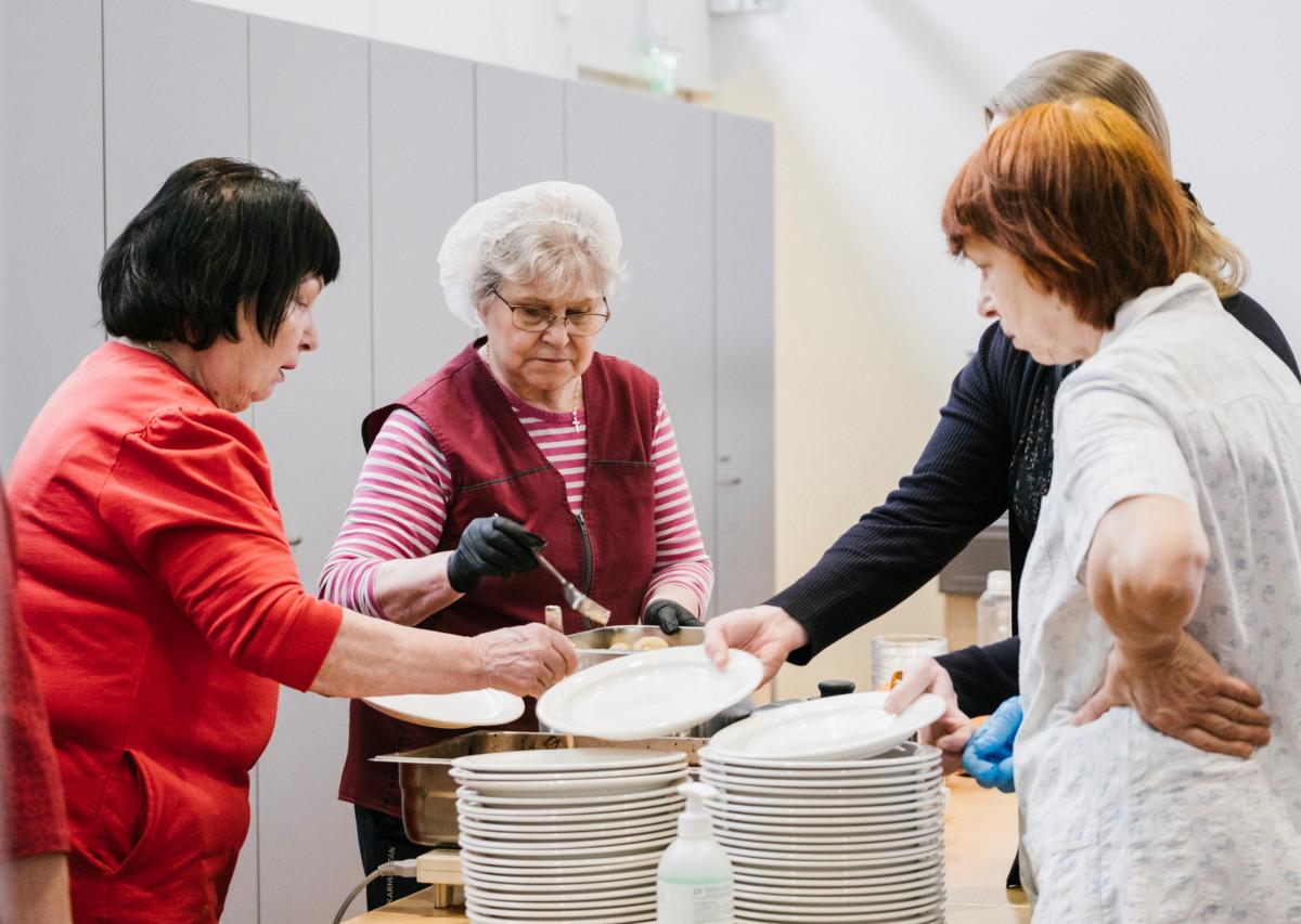 Vapaaehtoistyötä tekevien Maija Sibeliuksen (vas.) ja Mari Leinosen tehtäviin tiistain lounasruokailussa kuuluu muun muassa ruoan jakaminen.
