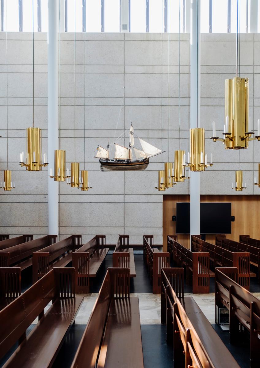 Kirkkosalin kattoon ripustettu votiivilaiva symboloi Lauttasaaren merellisyyttä.