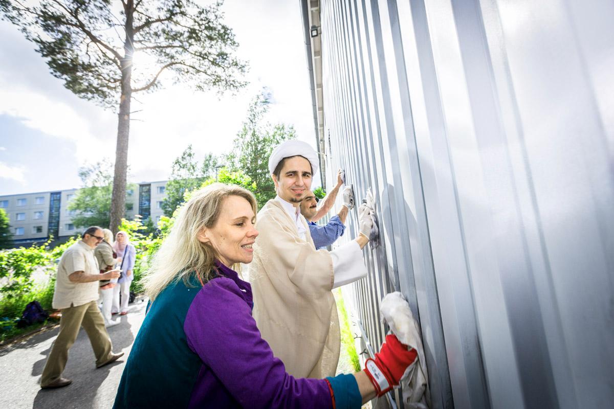Vihaviestin poistamisessa moskeijan seinästä auttoi viitisenkymmentä ihmistä, mukana myös kristittyjä kuten Helsingin seurakuntayhtymän uskontodialogipappi Heidi Rautionmaa etualalla. Hänen vieressään on moskeijan imaami Abbas Bahmanpour.