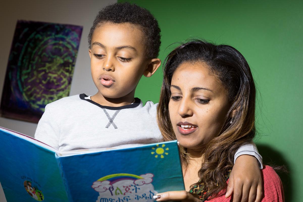 Tsedey Gebremariam ja hänen poikansa Brook Alemayehu lukevat Gebremariamin tekemää kirjaa amharaksi.