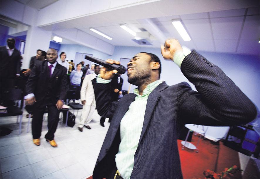 Jumalan palvontaa Sörnäisissä. Femi Oyeniyi johdattaa Hosanna Chapel -seurakuntaa lauluun ja tanssiin. Kuva: Esko Jämsä