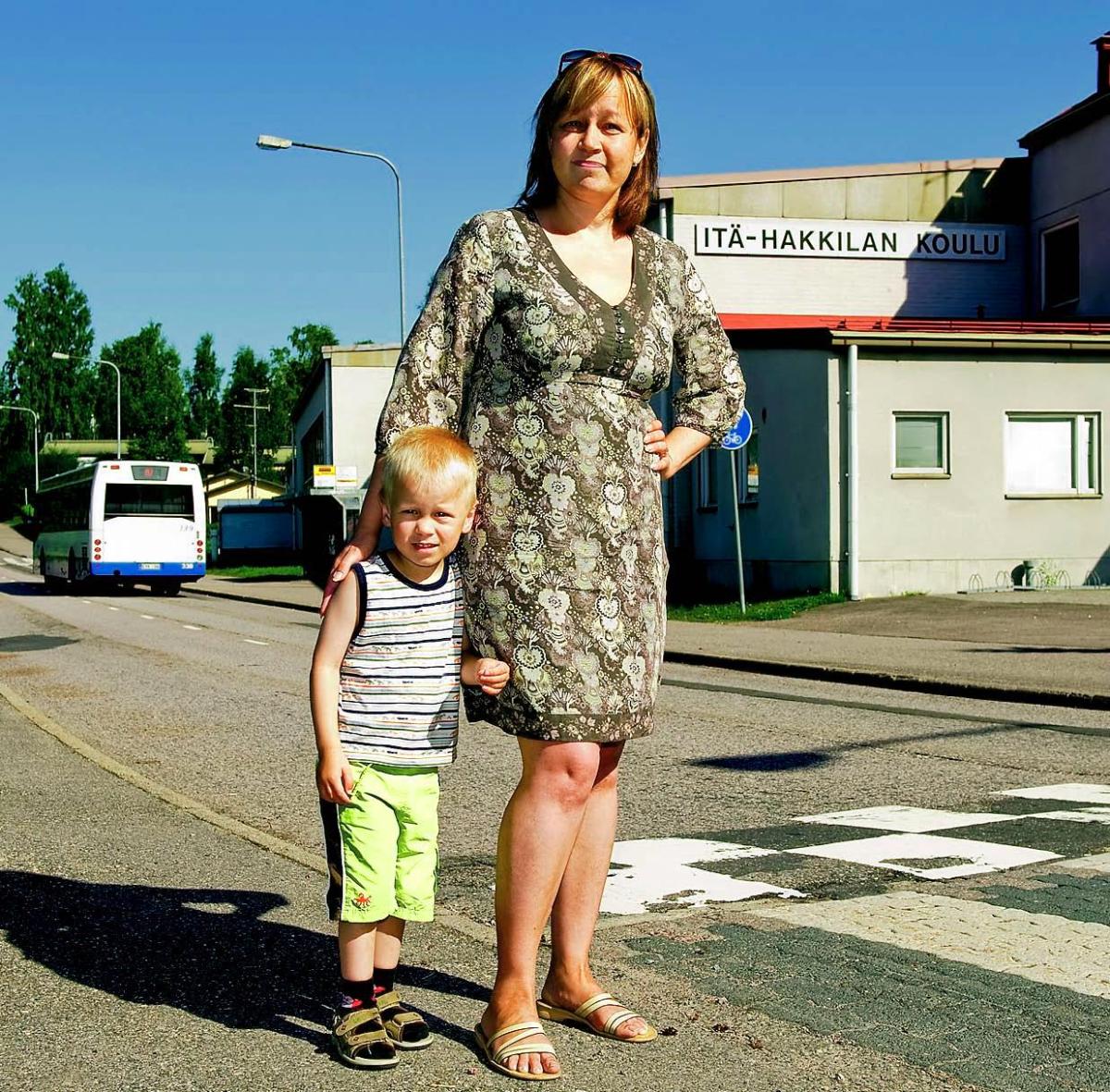 Heidi-Maria Kokkonen valvoo ensimmäisenä kouluaamuna, että Itä-Hakkilan koululaiset pääsevät turvallisesti tien yli. 3-vuotiaan Eelin ei tarvitse vielä koulumatkoista huolehtia.