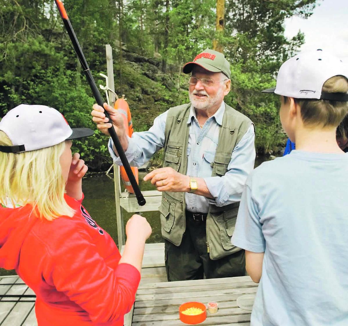 Kalakummi Risto Tiukkanen opasti Vantaankosken seurakunnan lapsia kalastuksen iloihin Tontunniemen leirikeskuksessa Asikkalassa.