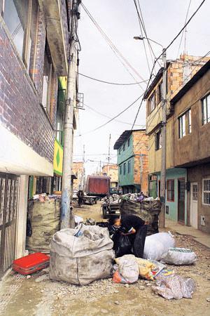 Enrique asuu sorakadun varrella Suban esikaupunkialueella. Roskasäkit ovat jätteitä työkseen kierrättävien naapureiden työsaalis. Kuva: Javier Cuevas