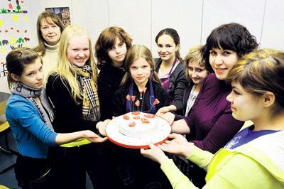 Tytöt tekivät ystävänpäivän suklaakakkuun sokeripäällyksen ja romanttisia koristeita. Kuva: Miska Reimaluoto
