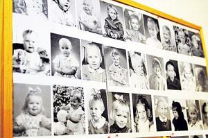 Yhteistilojen seinälle on laitettu asukkaiden lapsuudenkuvat.Kuva: Miska Reimaluoto