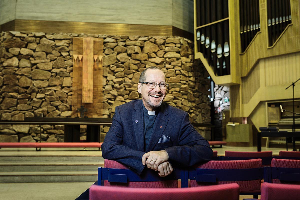Kirkkoherra Jouni Turtiainen on tyytyväinen uuteen remontoituun kirkkoon. Kirkkosalin kiviseinän lohkareet on louhittu 1970-luvulla rakennuspaikalta.