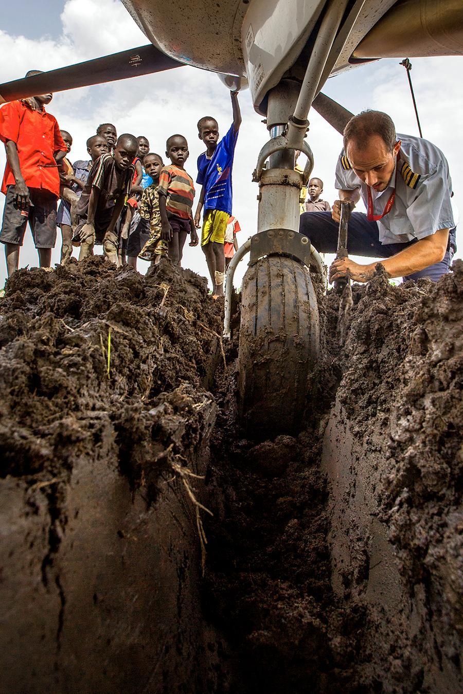 Lentäjä Ryan Unger kaivaa Cessna Caravan -konetta pois Leerin kiitoradan pehmenneestä kohdasta Sudanissa.