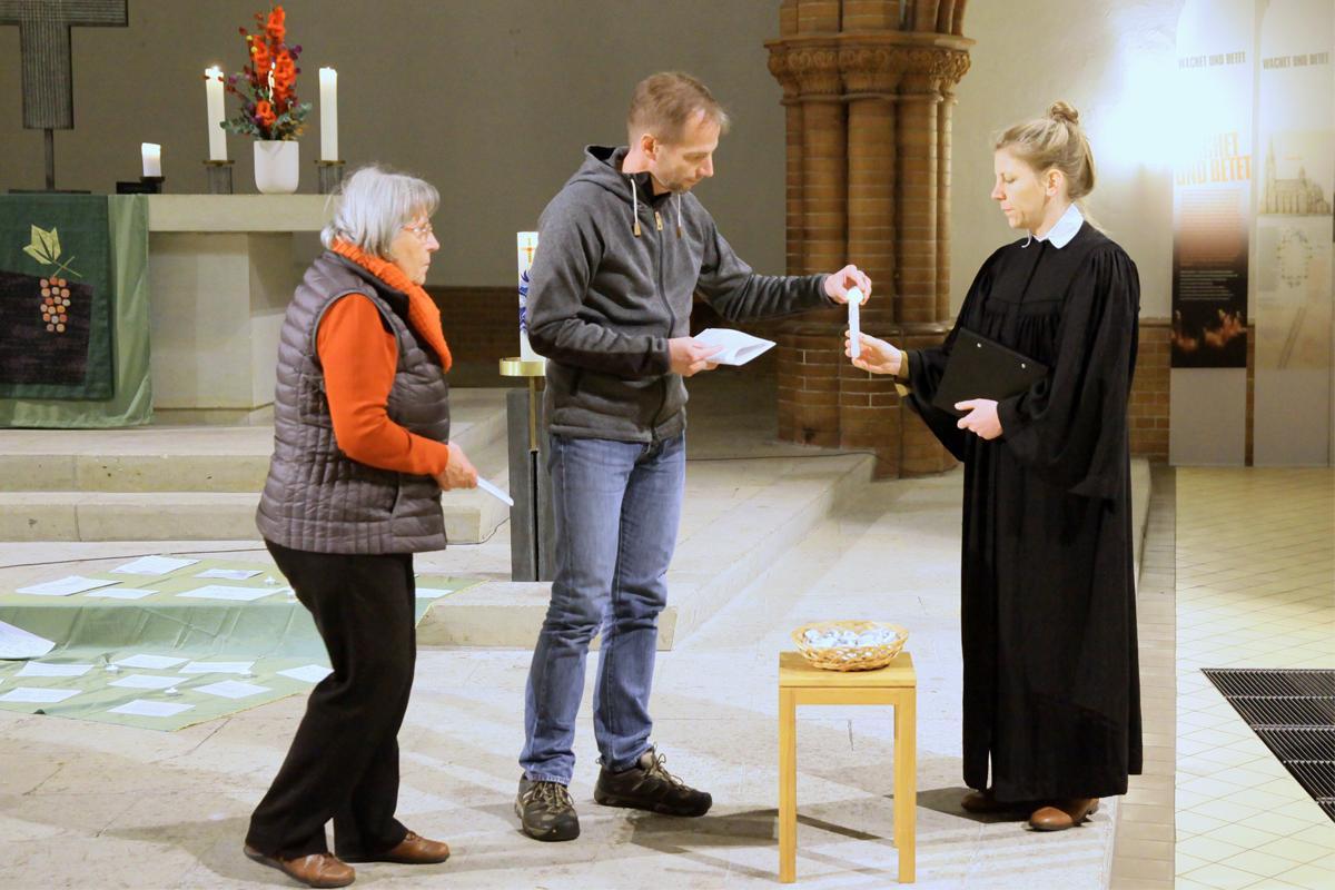Pastori Almut Bellman sytyttää Markus Wolfgramin ja Lilo Heinen kynttilät kiitosrukouksen ajaksi.